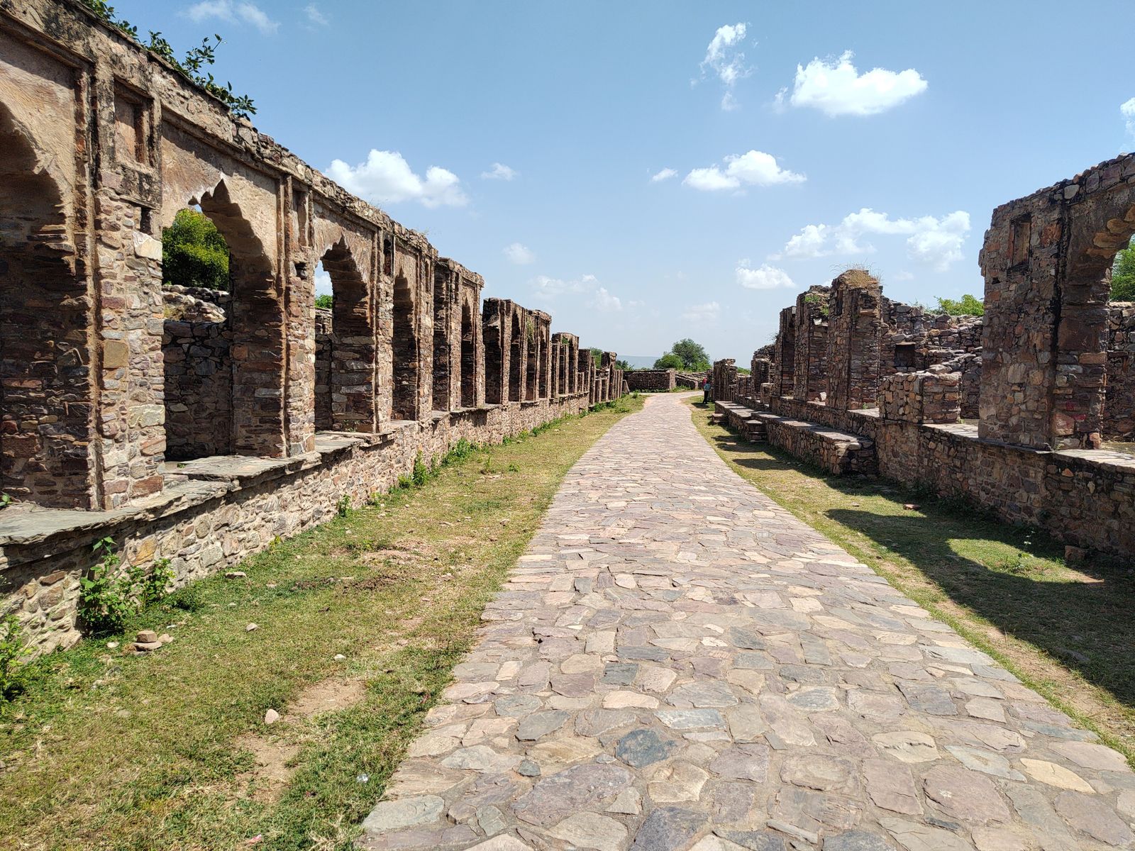 The ruined market street of Bhangarh, with rows of roofless stone shops on either side