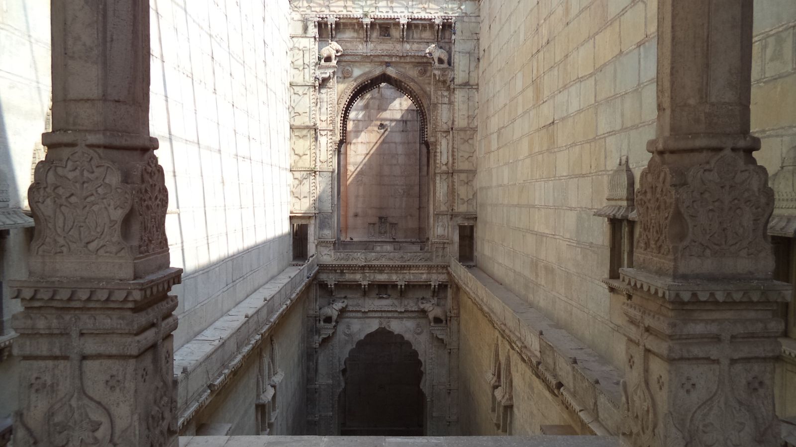 Carved stone steps, pillars and arched gateways descending into Raniji ki Baori stepwell in Bundi