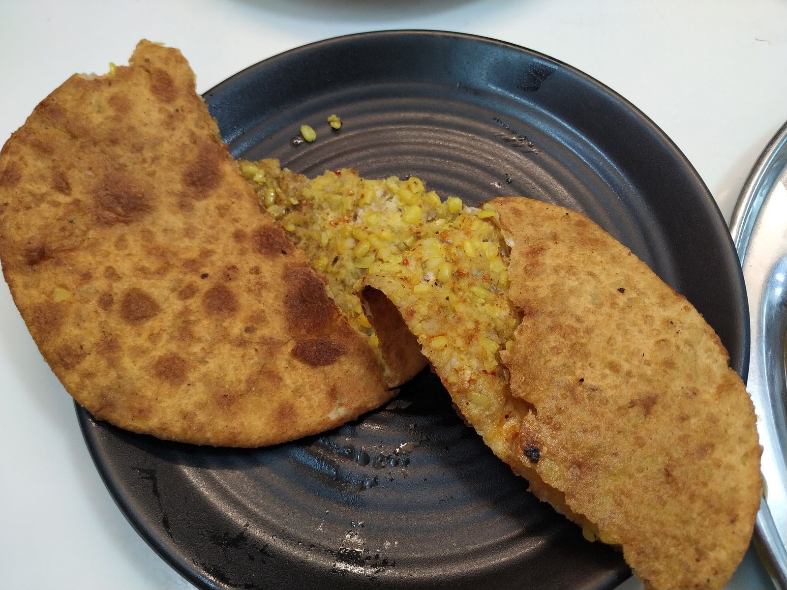 Stuffed parathas frying in an iron pan in a shop in Paranthe Wali Gali, Old Delhi