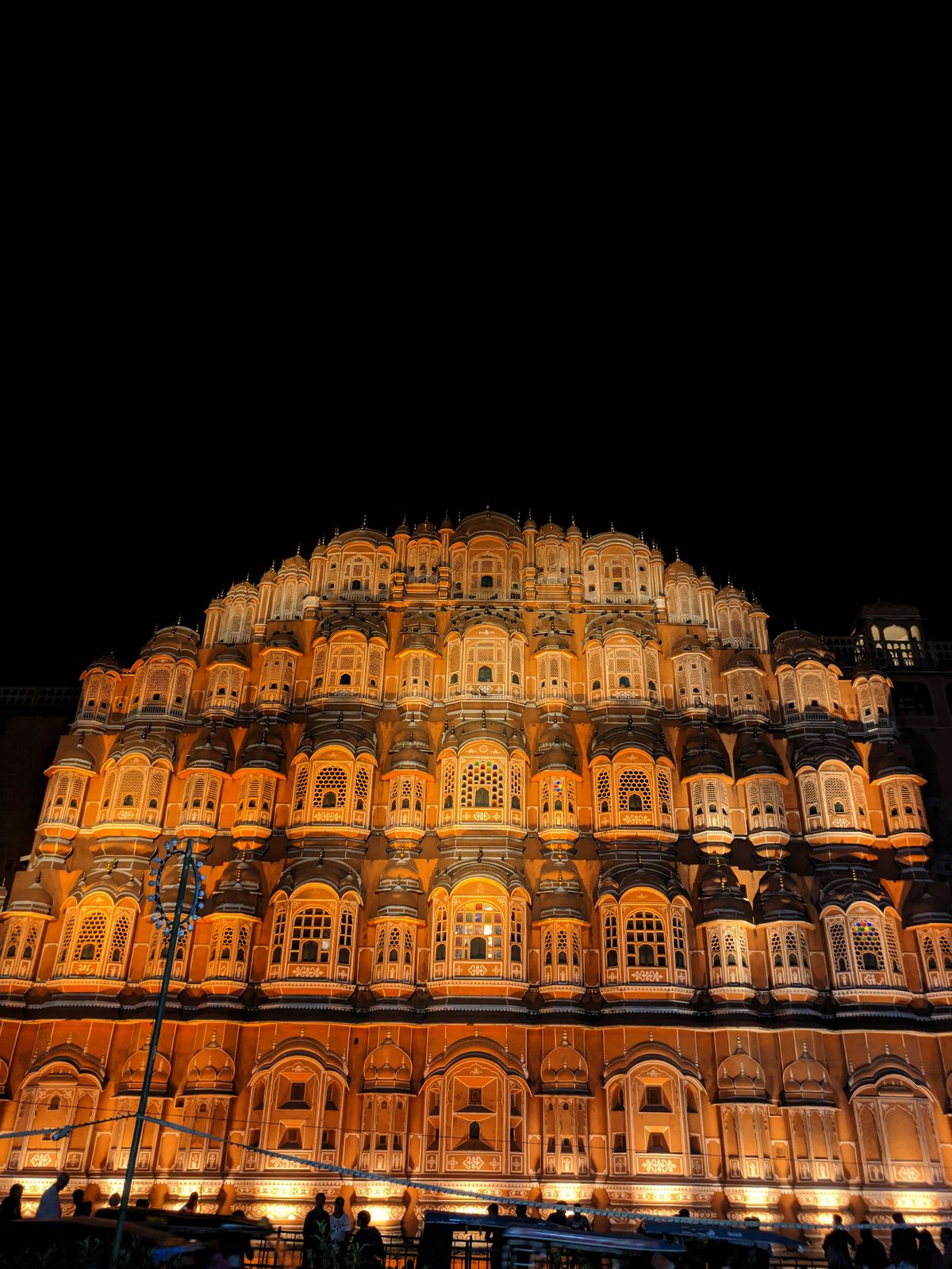 Hawa Mahal lit up at night above the bazaar in Jaipur
