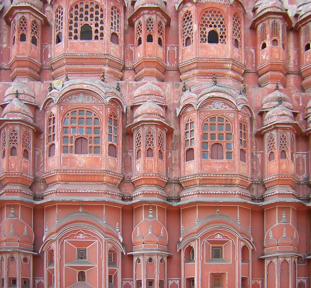 The honeycomb of small jharokha windows on the pink facade of Hawa Mahal in Jaipur