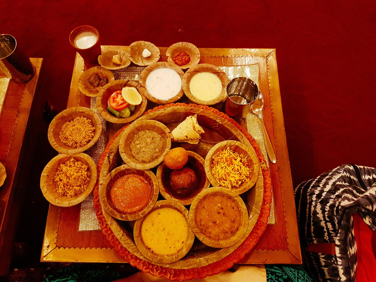 A Rajasthani thali with dal, curries, chutneys and breads in small metal bowls