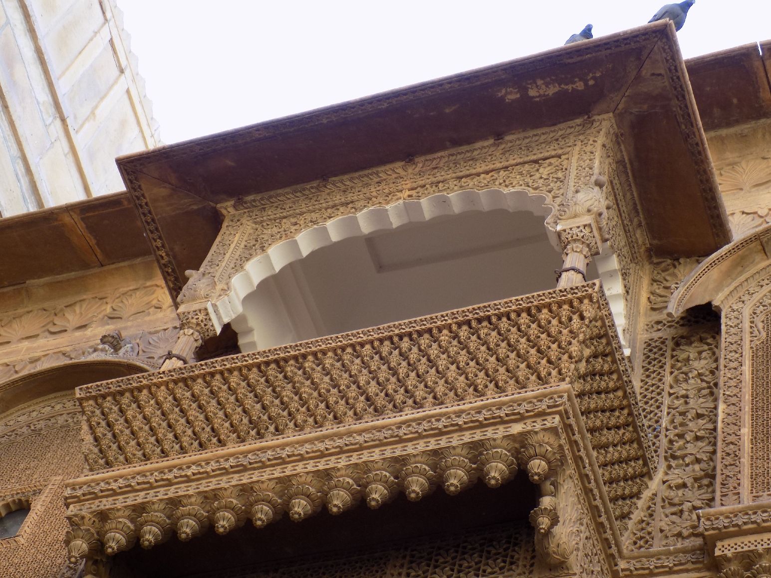 Carved projecting balconies and curved stone roofs on the top storey of Salim Singh ki Haveli in Jaisalmer
