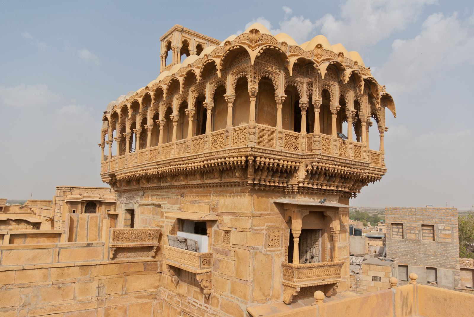 The tall haveli of Salim Singh in Jaisalmer, its plain lower storeys topped by a projecting floor of carved balconies