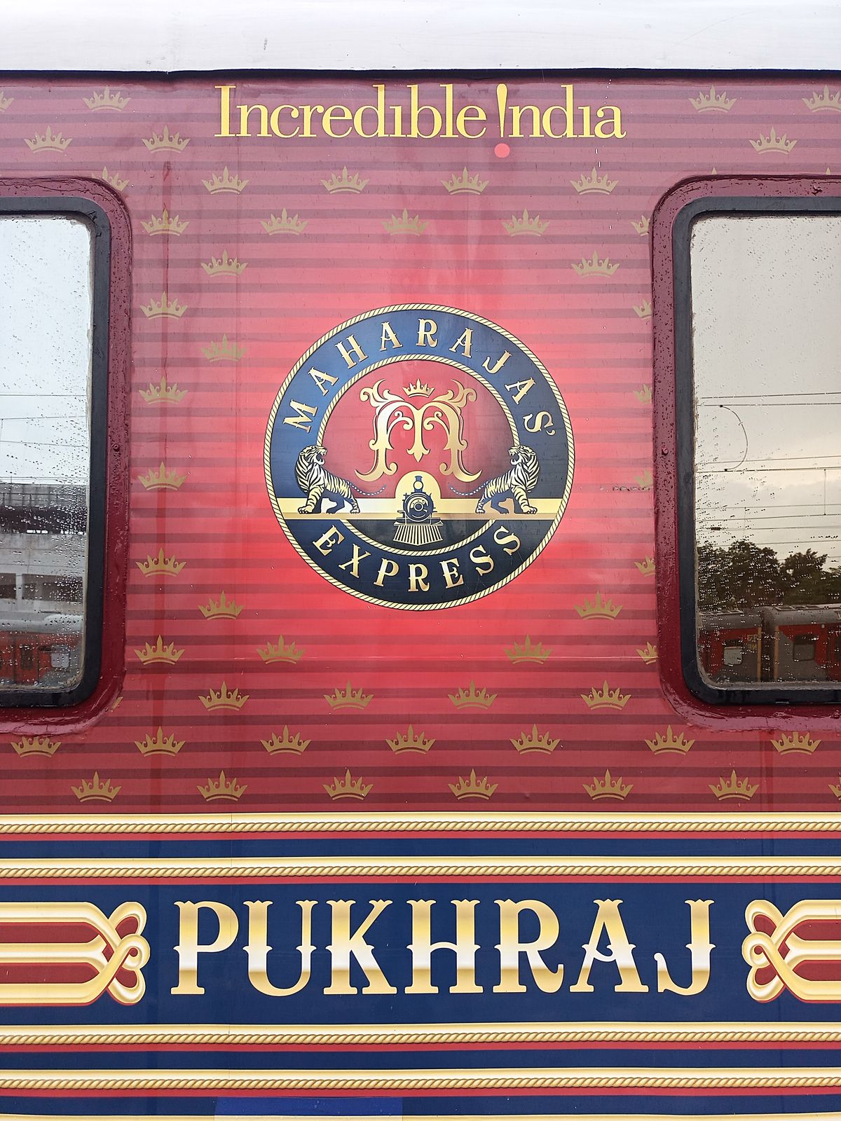 The Maharajas' Express luxury train in its deep red livery at a railway platform