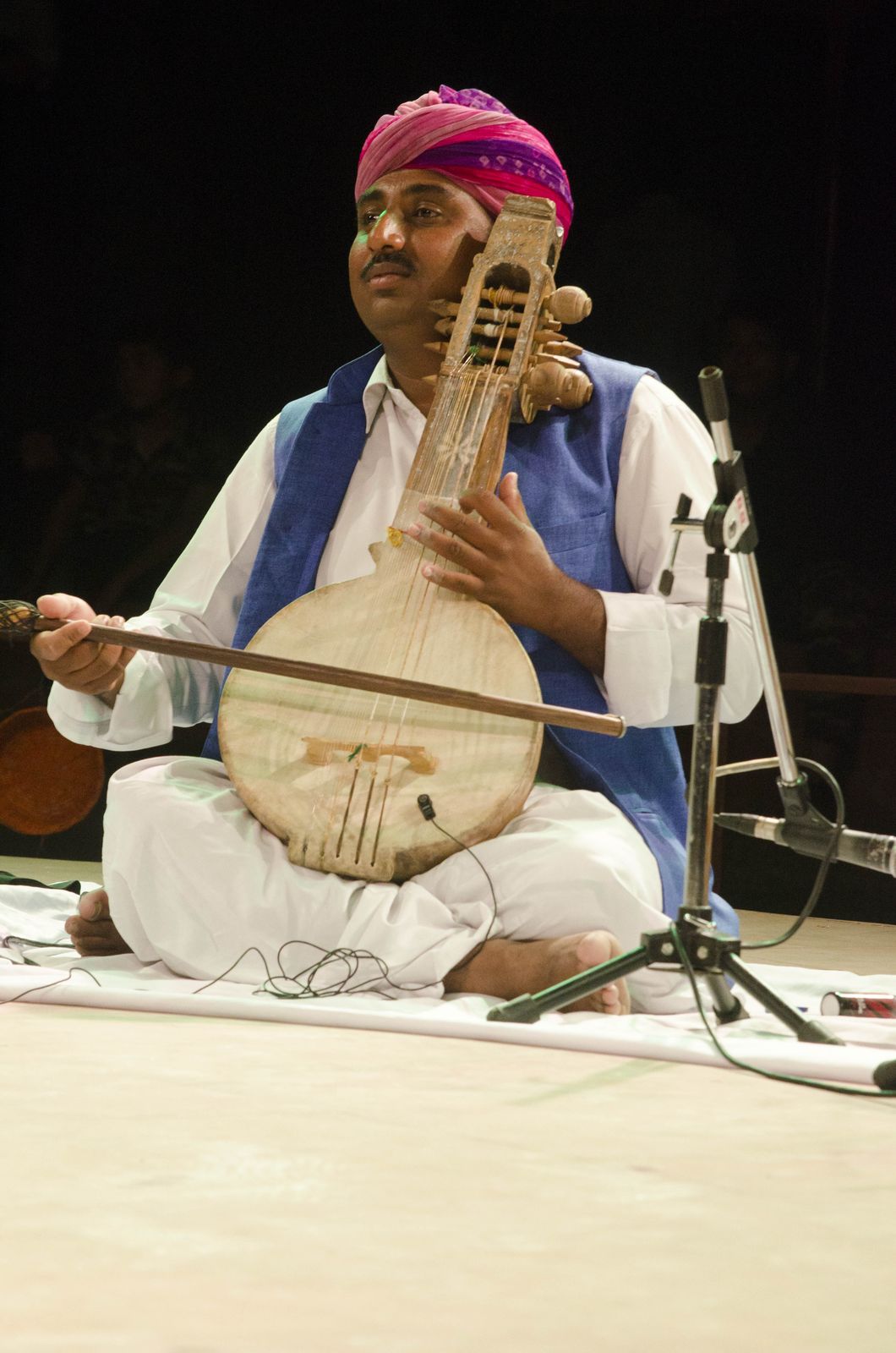 A Manganiyar musician in a turban playing the bowed kamaicha