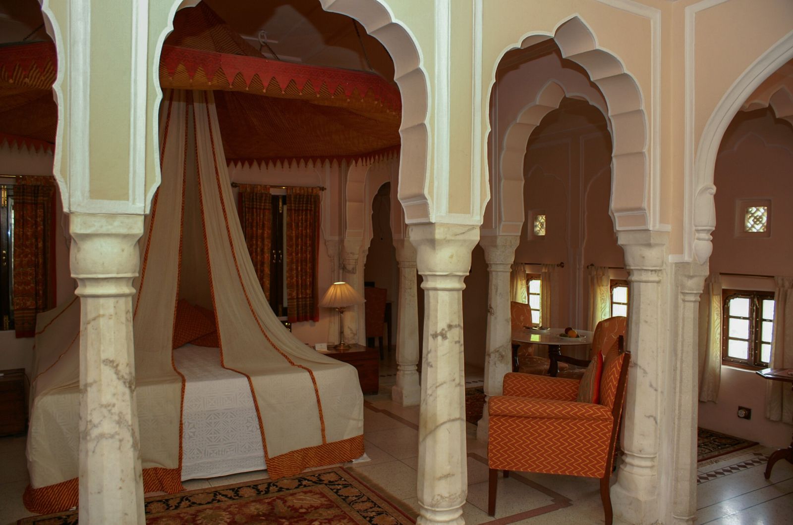 A carved canopy bed in a guest suite at Samode Palace