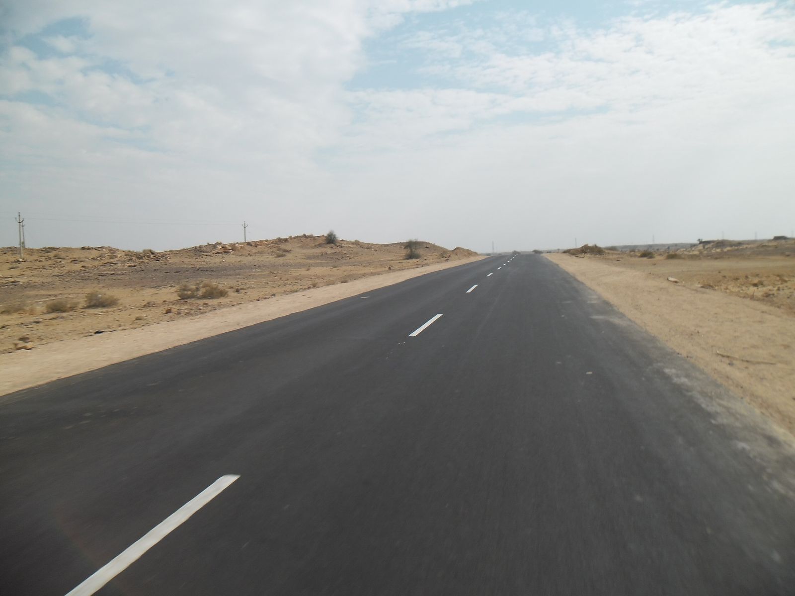 A road running straight into the Thar desert near Jaisalmer