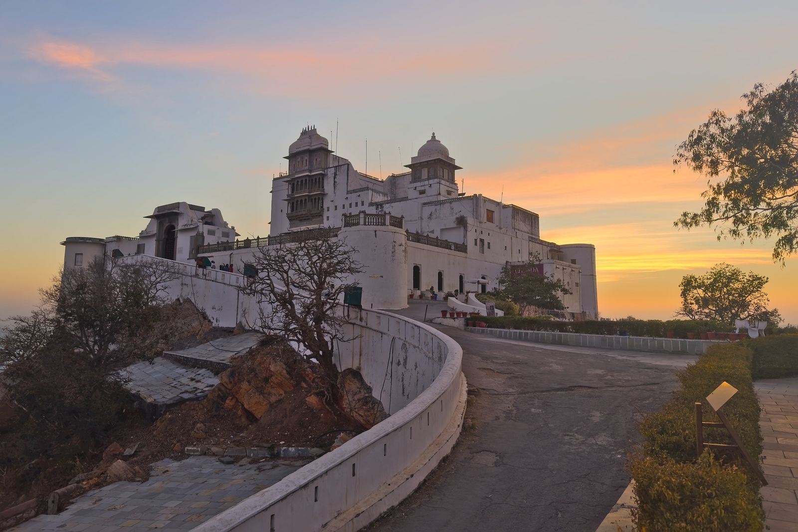 The white Sajjangarh Monsoon Palace with its turrets and arches on a hilltop above Udaipur