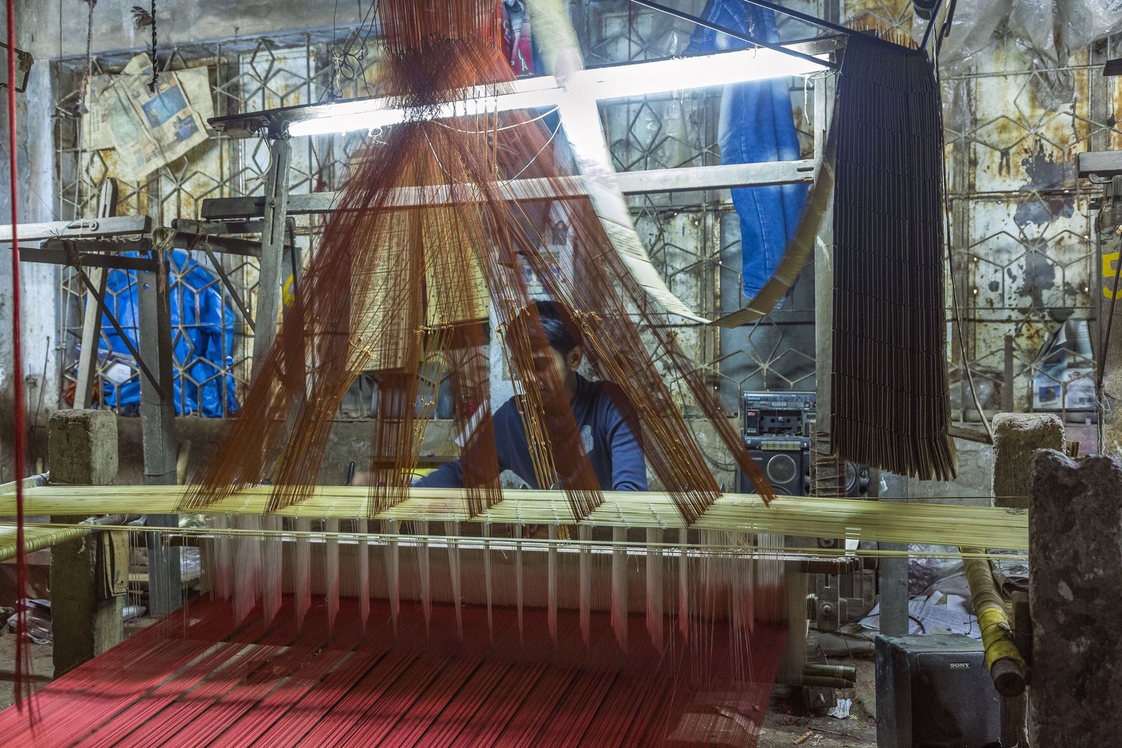 A weaver working at a handloom, weaving Banarasi silk cloth